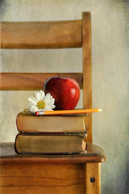 Apple and books on old school chair